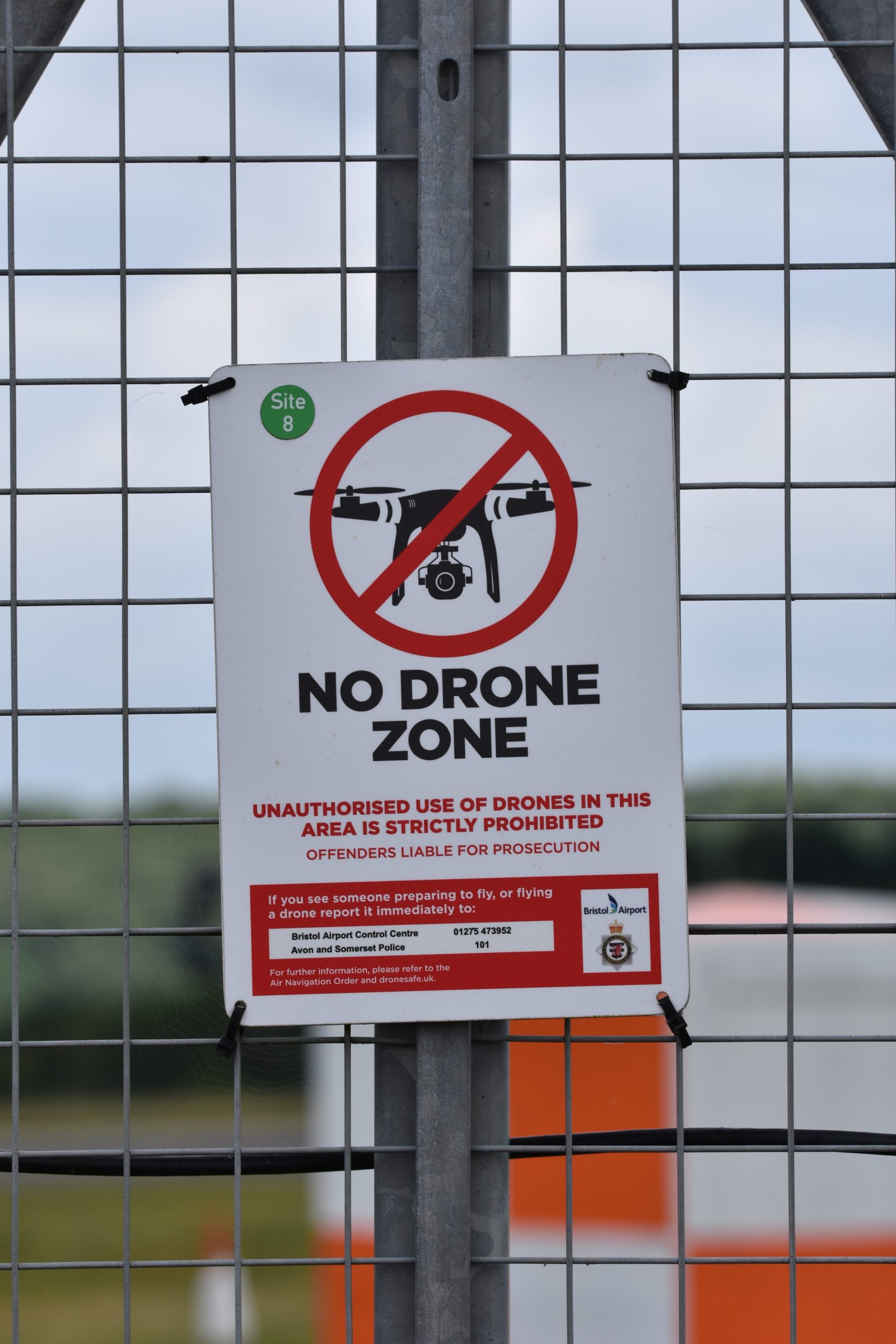 A sign on a fence that says no drone zone